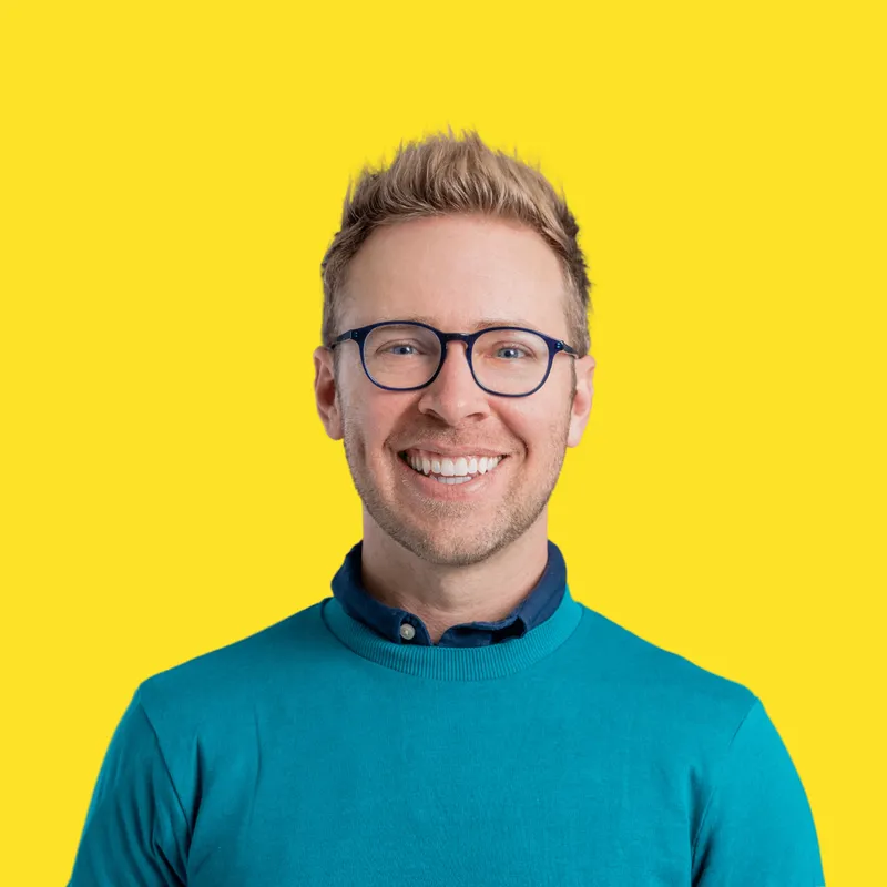 Headshot of Nick Gray in a yellow background