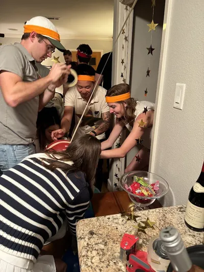 Party guests building balloon towers during a team competition at a 30th birthday party