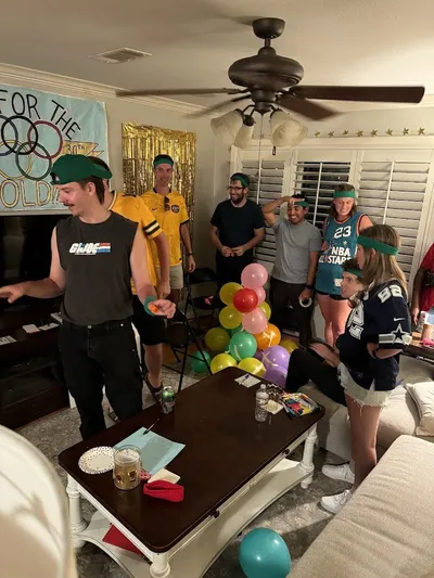 Party guests building balloon towers during a team competition at a 30th birthday party