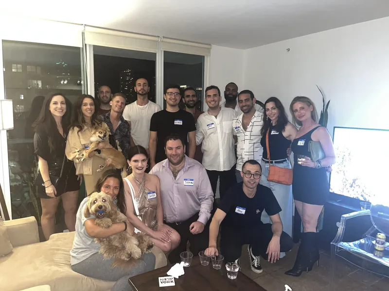 group of people with name tags smiling, 2 are holding dogs