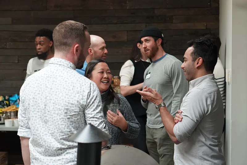 Office party guests wearing name tags and talking to each other