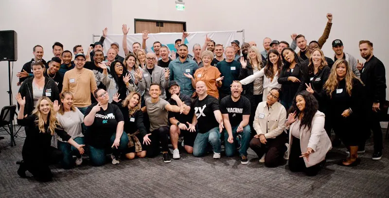 group of people smiling with name tags and raising their hands