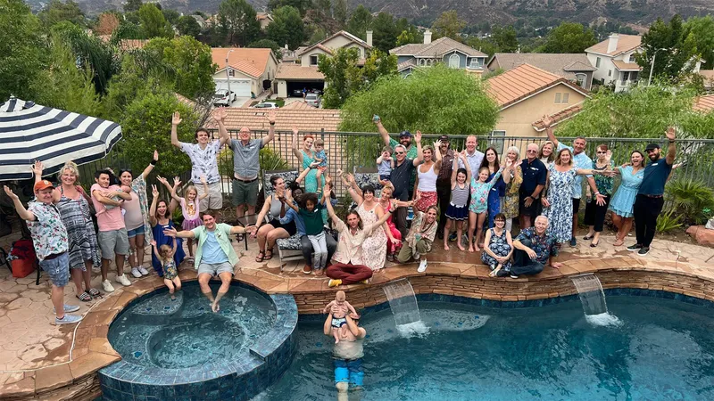 a group of people raising their hands at a swimming pool