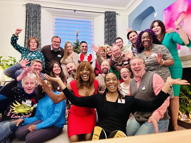 group of people smiling and raising their hands