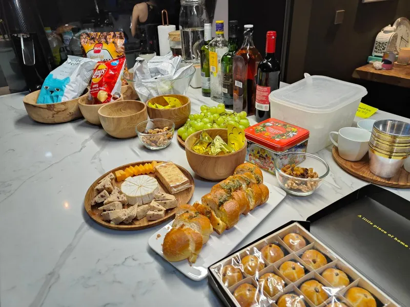 Island counter with snacks including breaks, cheese, grapes, potato chips, and drinks